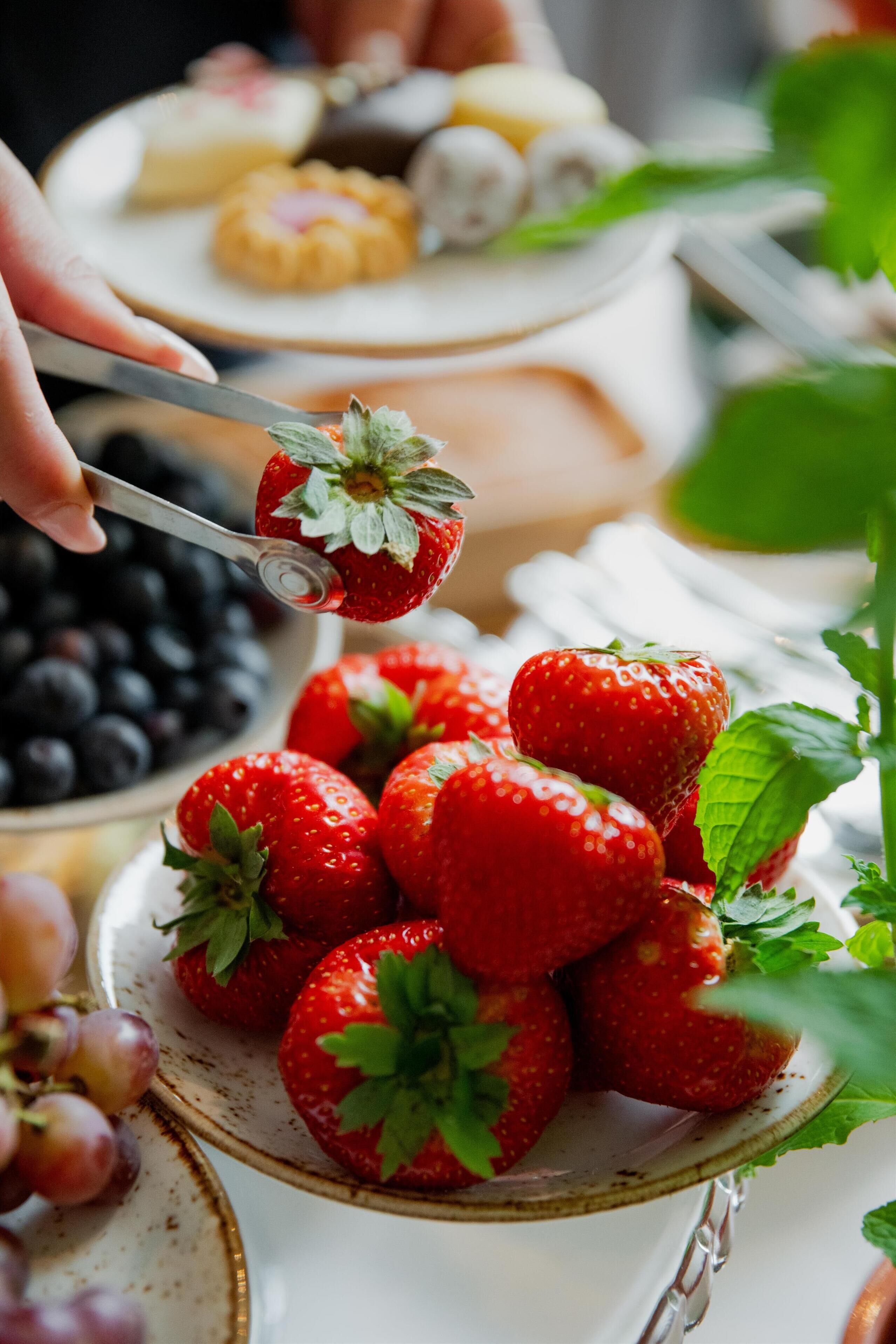 A plate of strawberries with a spoon.