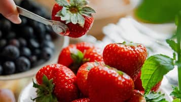 A plate of strawberries with a spoon.