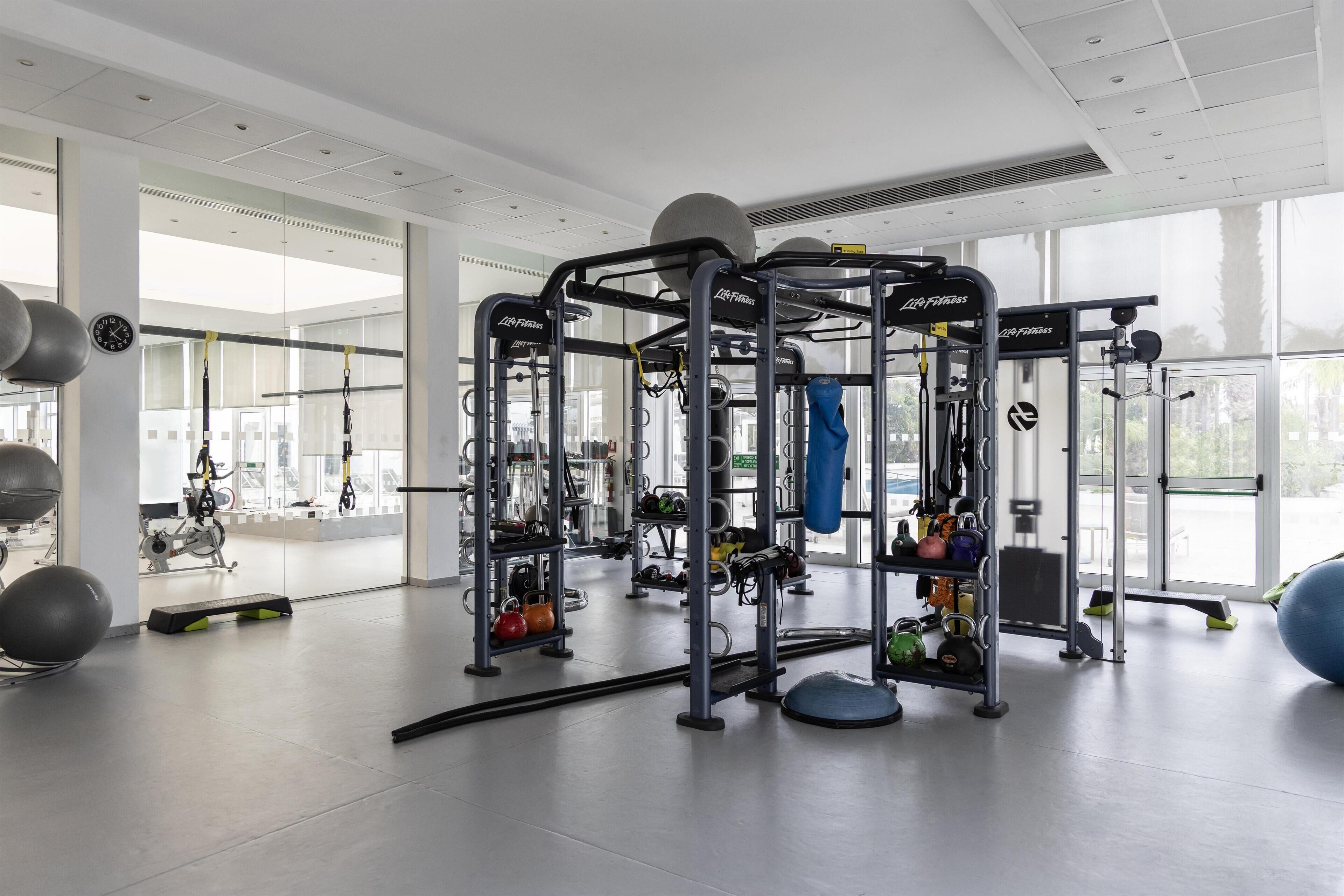 A gym with weightlifting equipment, exercise balls, and a variety of machines.