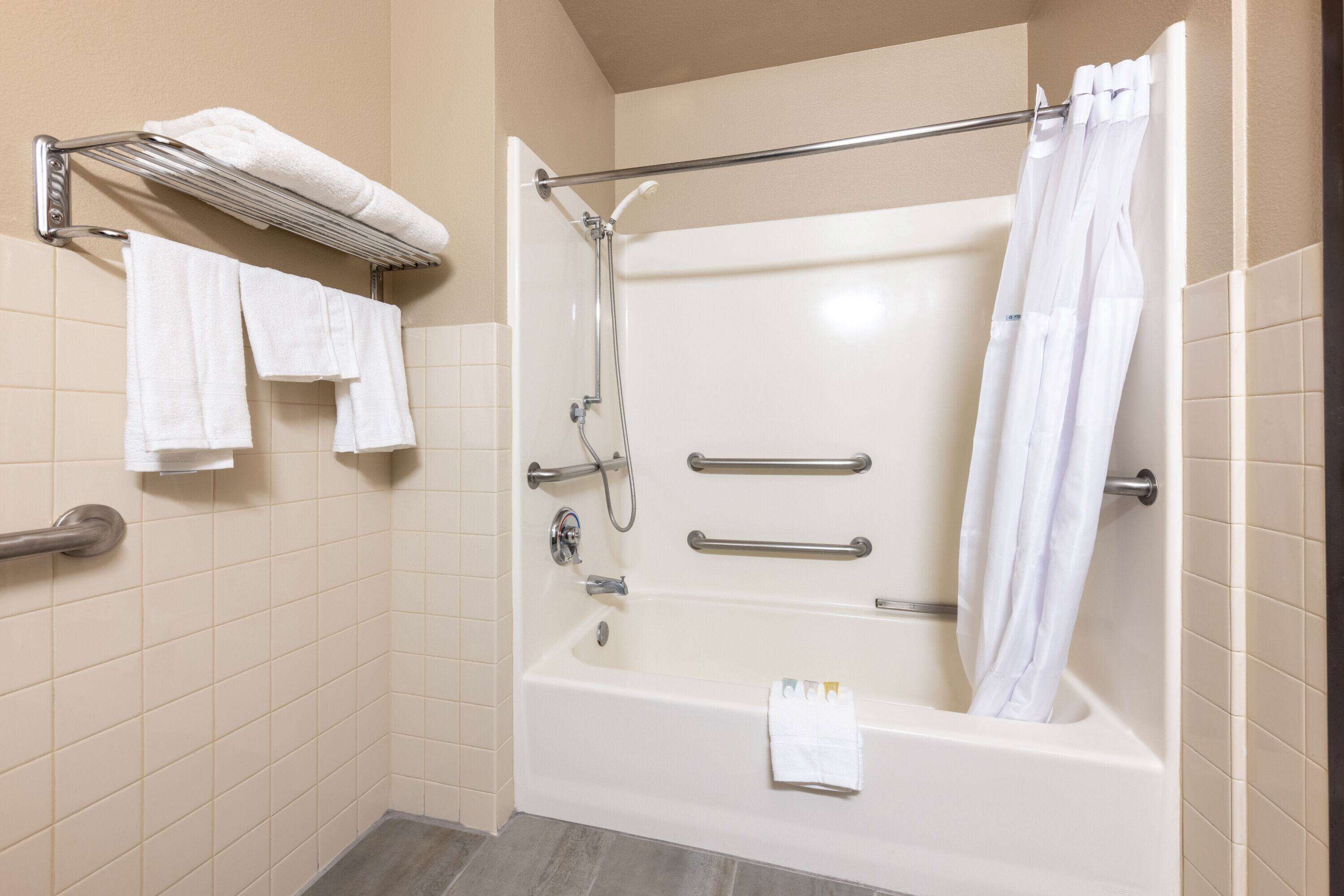 Un baño moderno con bañera, ducha y un perchero para toallas.