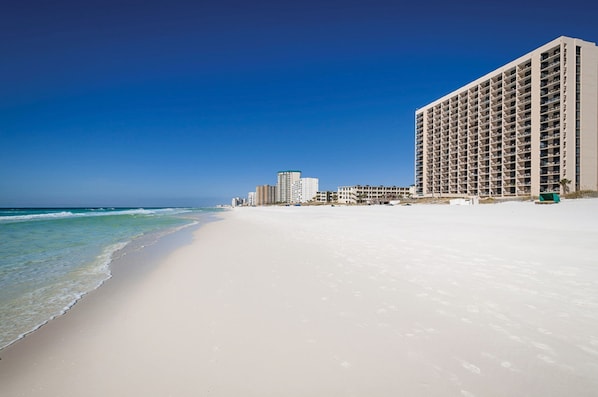 A beachfront hotel with a sandy beach, ocean view, and multiple high-rise buildings in the background. - SunDestin Beach Resort (Destin)