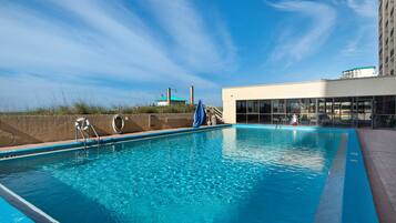 Een binnenzwembad, een buitenzwembad, ligstoelen bij het zwembad