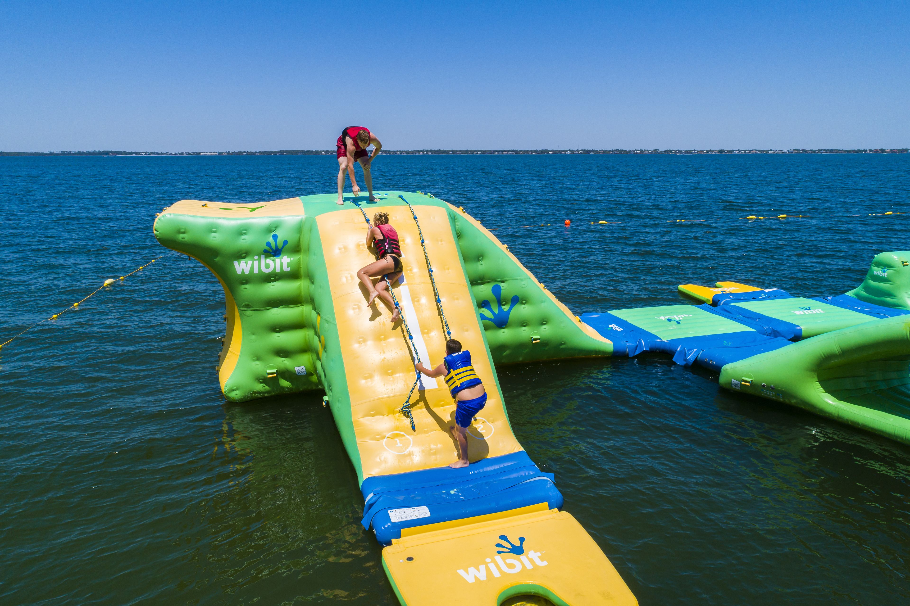 A water slide with inflatable structures and a clear view of the water.