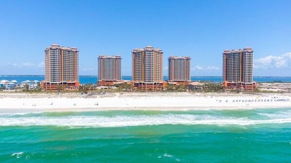 A beachfront hotel with multiple high-rise buildings, a sandy beach, and the ocean. - Portofino Island Resort (Pensacola Beach)