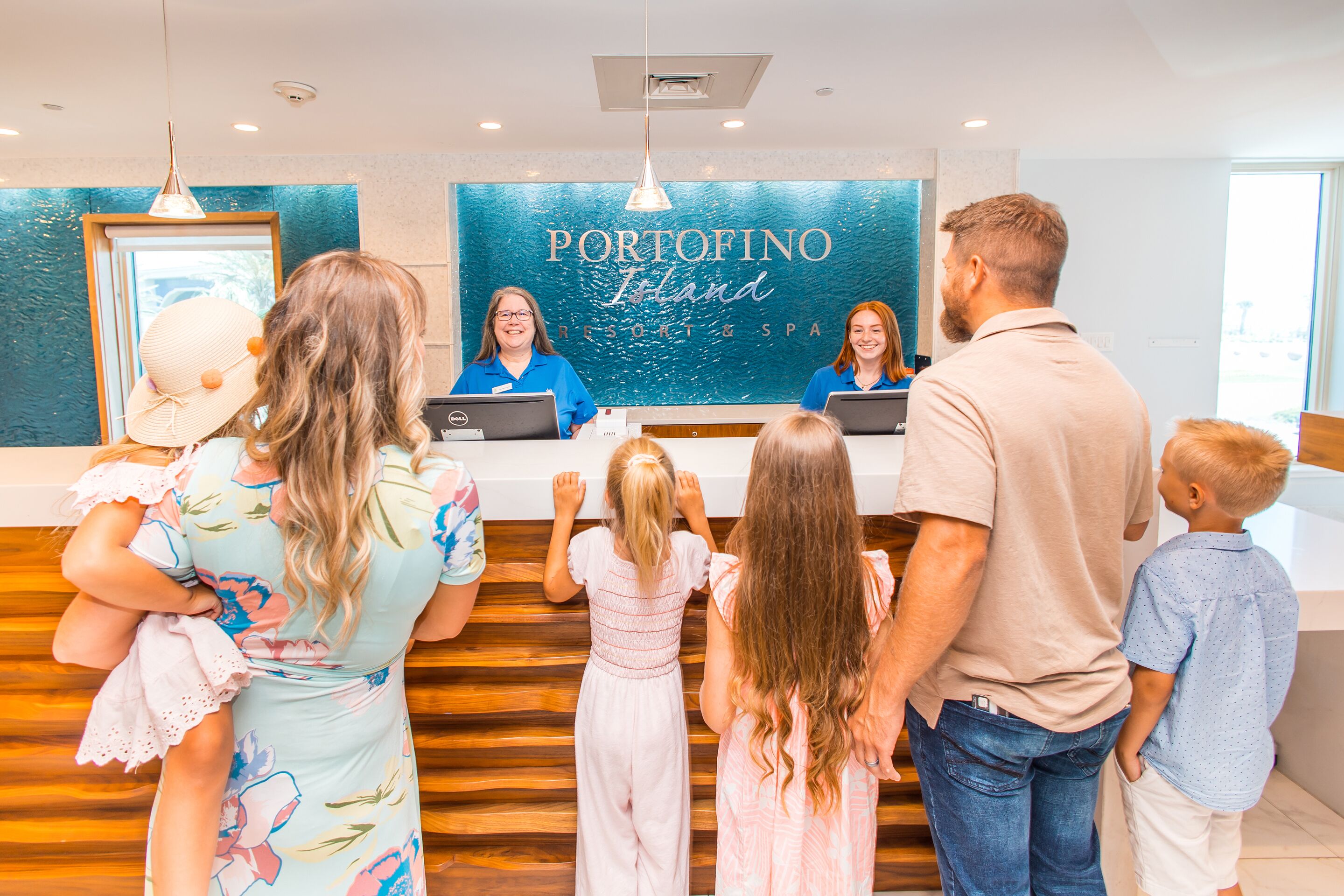 Een receptiebalie met een bord waarop 'Portofino Ireland Resort & Spa' staat, en een houten vloer.
