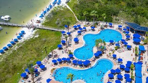 Un resort con varias piscinas, tumbonas y sombrillas.