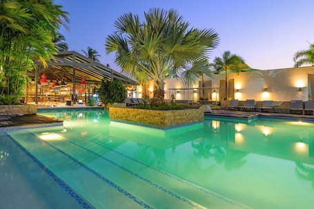 Una piscina al aire libre, sillones reclinables de piscina