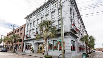 Un edificio histórico con entrada en esquina, palmeras y decoraciones festivas.