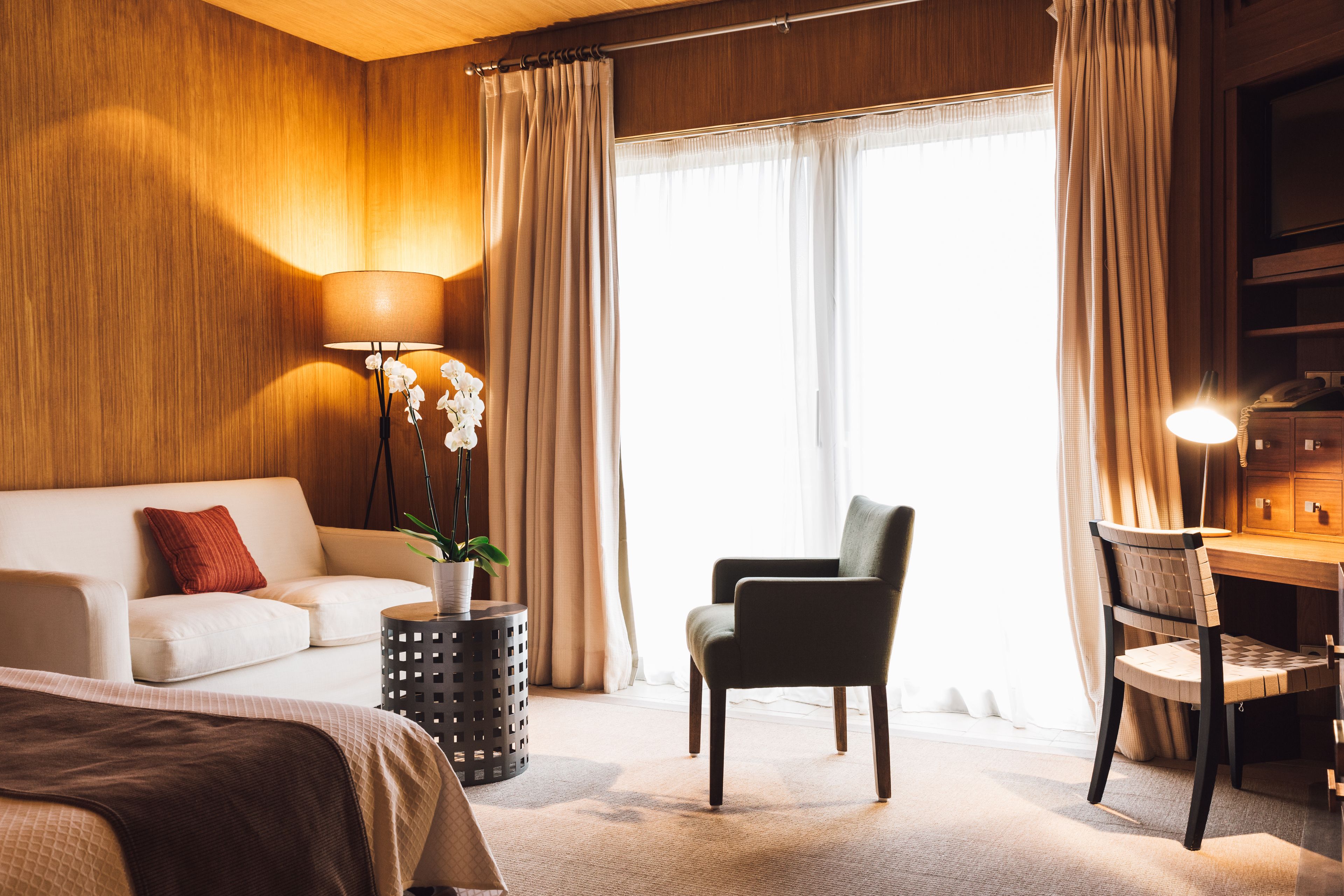 Een hotelkamer met een bed, een bank, een bureau en een stoel.