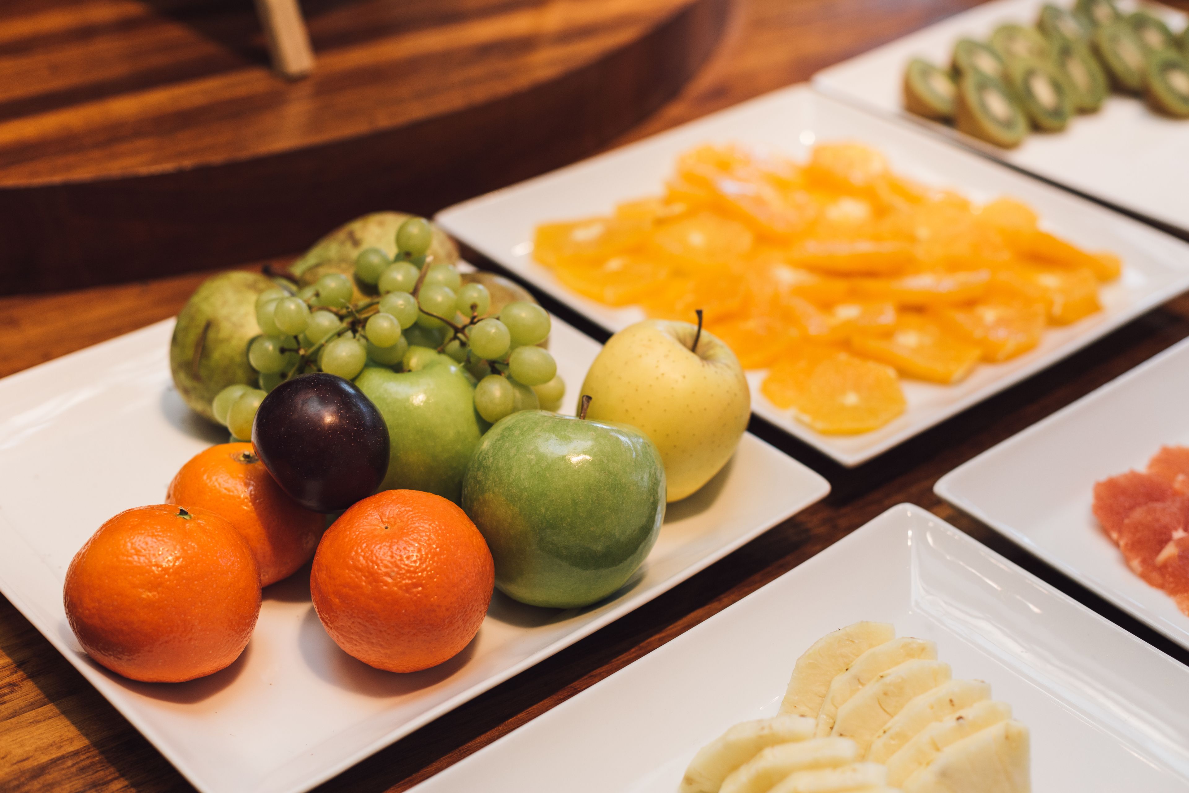 Una mesa con diversas frutas, como manzanas, naranjas y uvas.