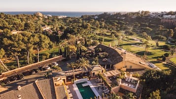 Relax by the pool surrounded by lush greenery and a scenic coastline.