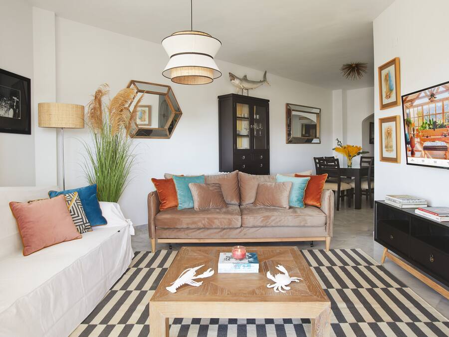 Una sala de estar con sofá, mesa de centro y aparador.