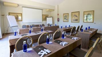 A conference room with tables set for meetings, equipped with water bottles, glasses, and name cards.