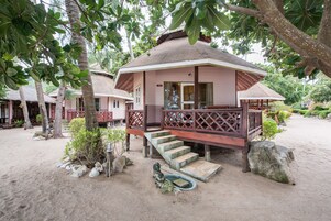 Ein Gebäude im traditionellen Stil mit einer Veranda und Stufen, die zu einer Tür führen.