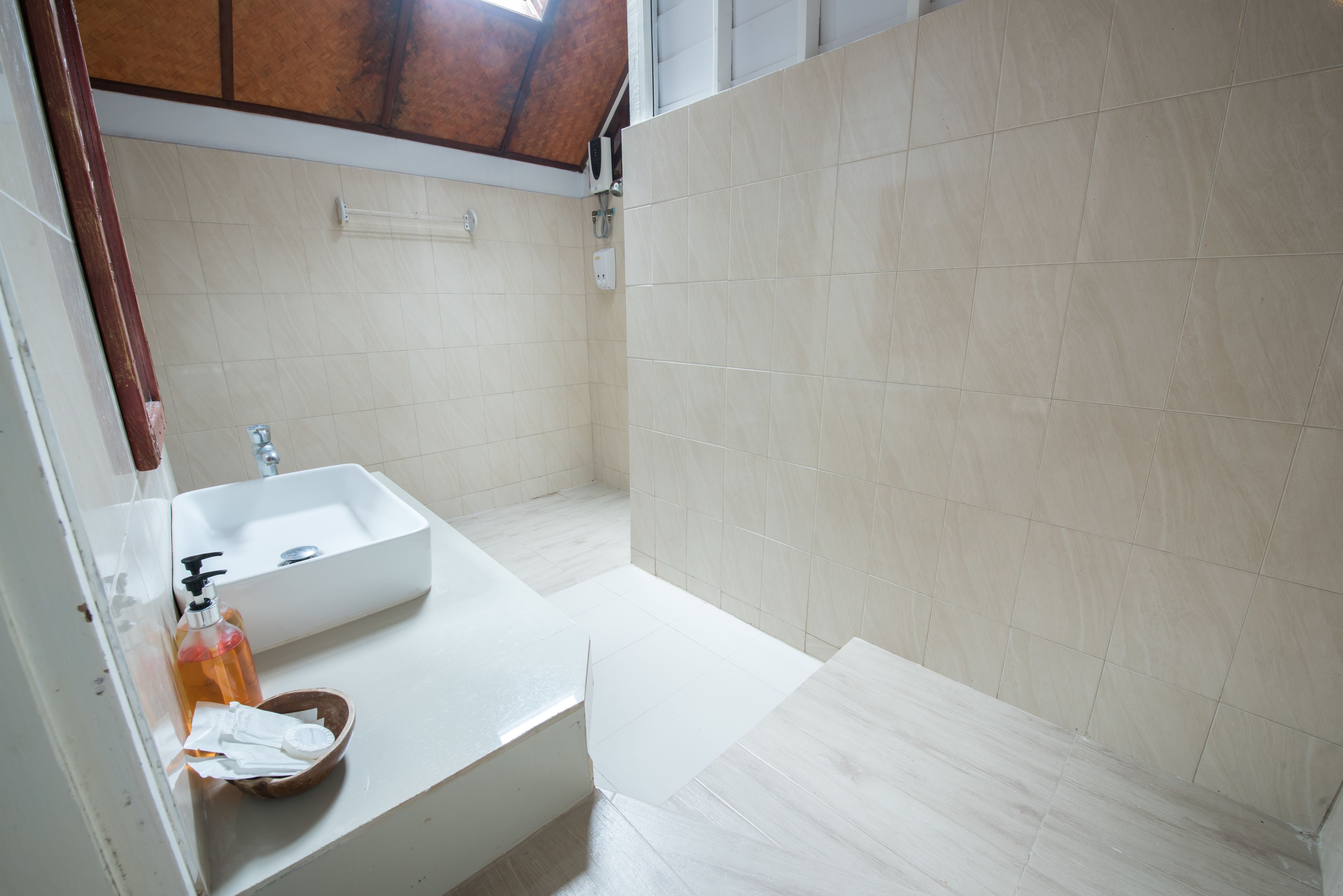 A bathroom with a white sink, a mirror, and a shower area.