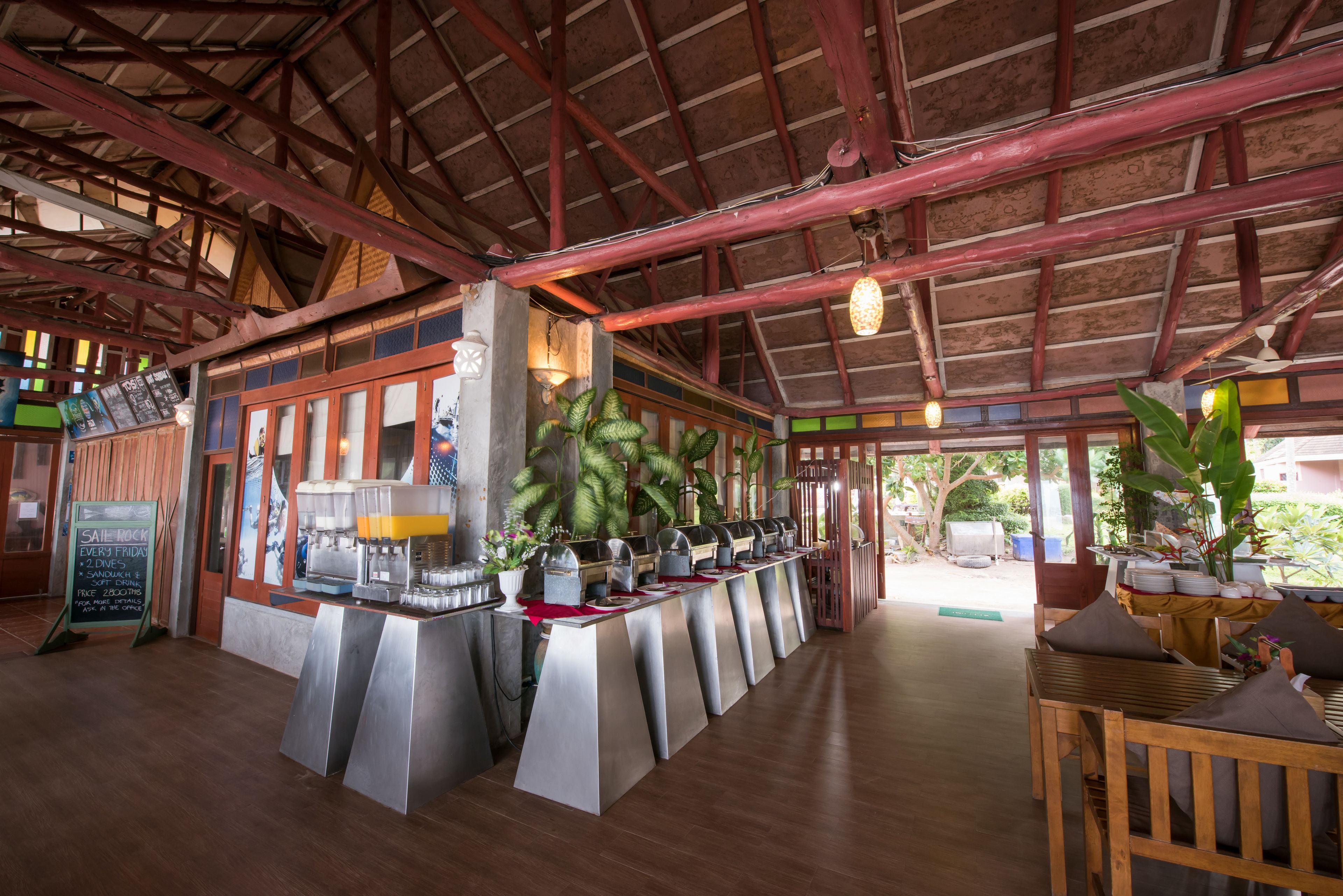 A restaurant with a long counter, multiple coffee machines, and a high ceiling with exposed beams.
