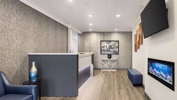 A reception area with a modern design, featuring a reception desk, seating area, and artwork on the walls.