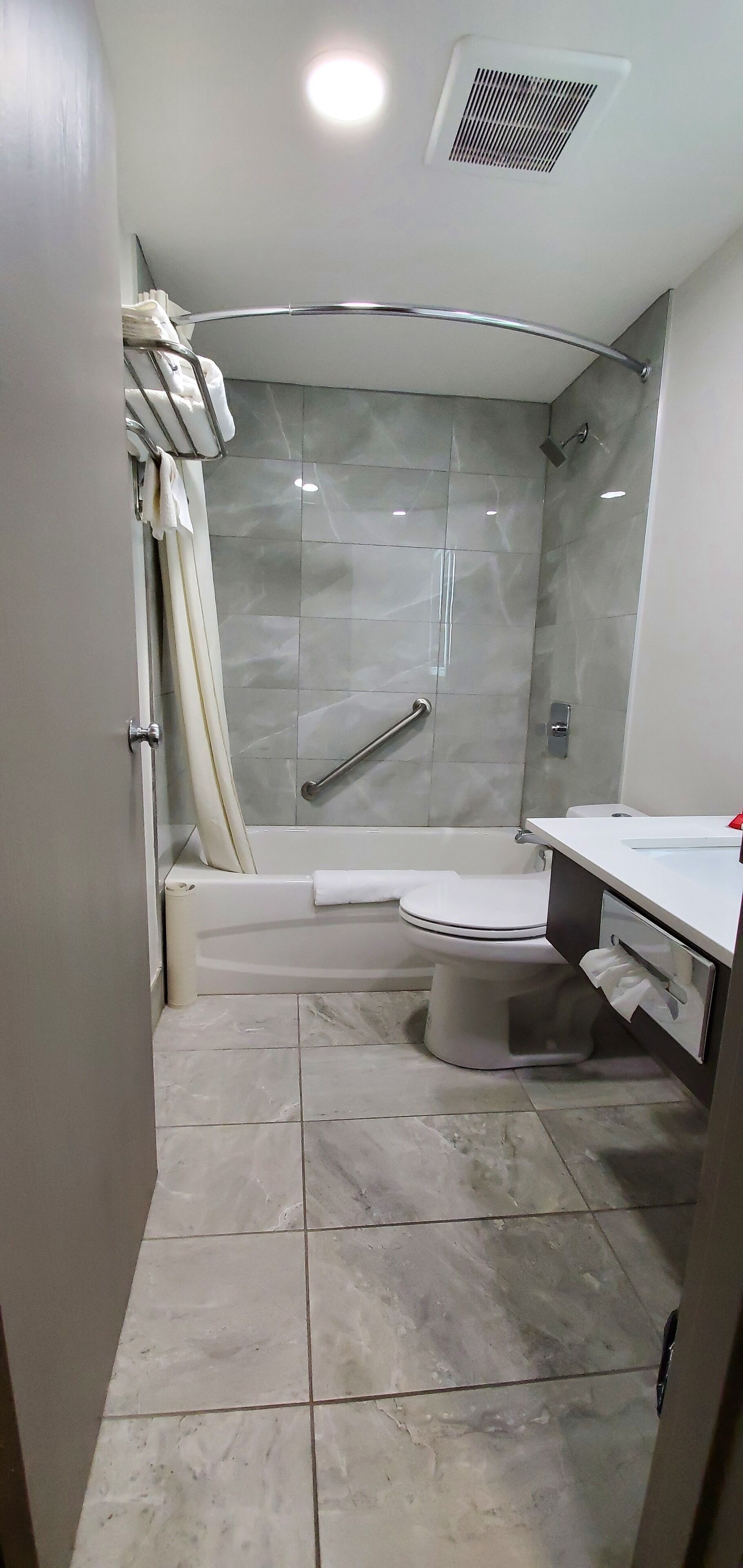 A modern bathroom with a glass-enclosed shower, a bathtub, and a toilet.