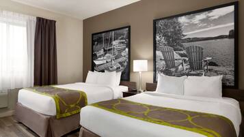 A hotel room with two beds, a large window with curtains, and two large black-and-white landscape paintings on the wall.