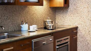 Una cocina moderna con armarios de madera, horno empotrado y lavavajillas.