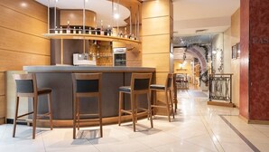 Een bar met een gebogen toonbank, barstoelen en een wijnkoeler.