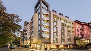Een hotel met meerdere verdiepingen, met een modern architectonisch ontwerp, voorzien van balkons en grote ramen.