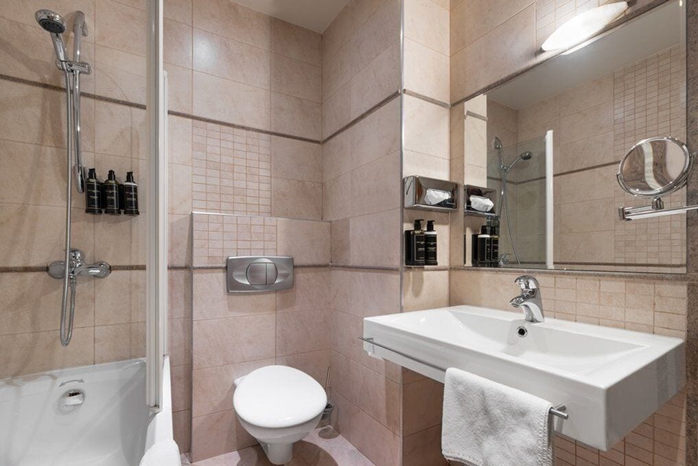 A modern bathroom with a shower, toilet, and sink.