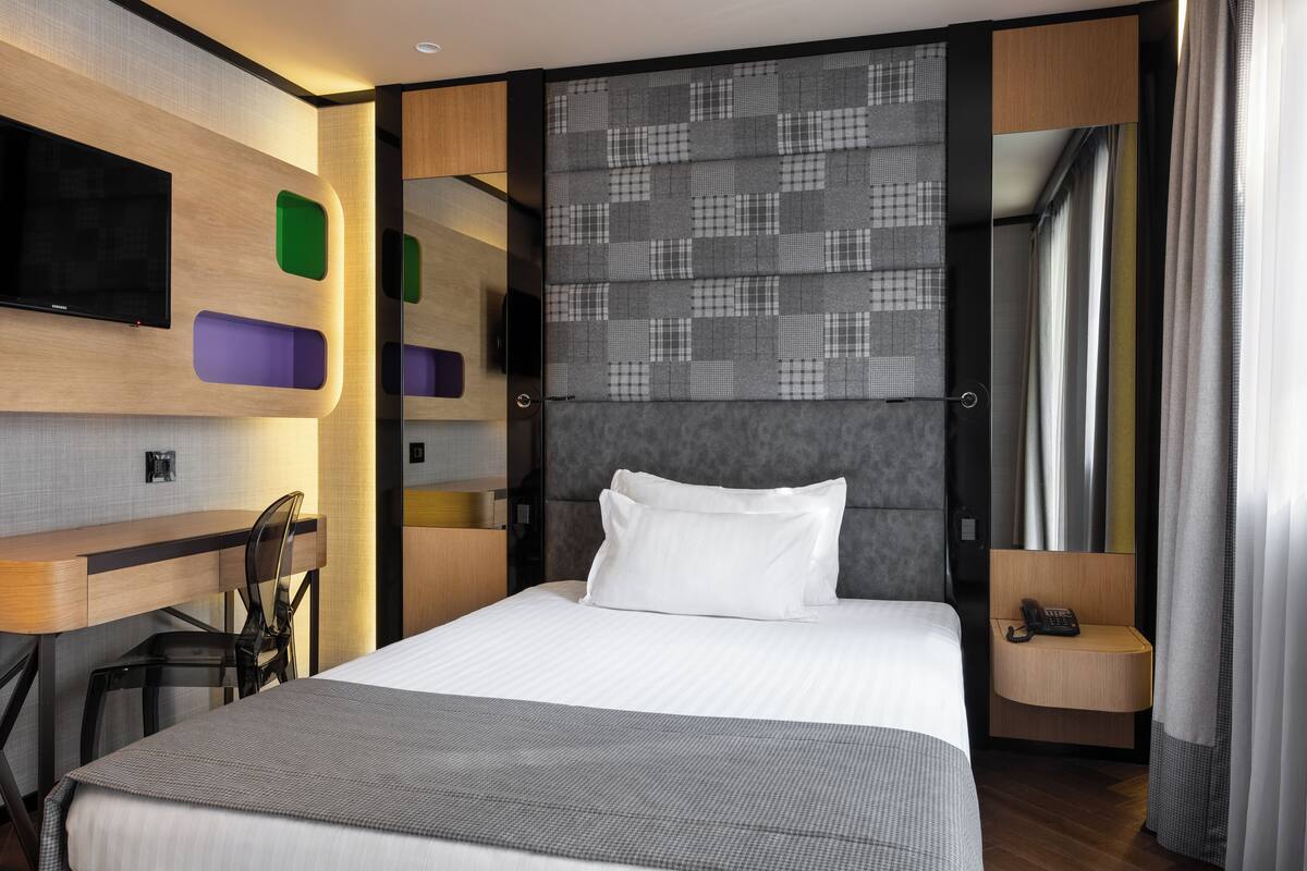 Een moderne hotelkamer met een groot bed, een bureau en een flatscreen televisie.