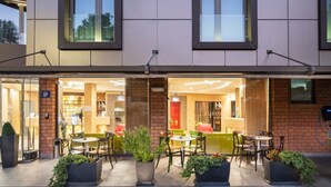 Hotel met terras, een zichtbare ingang en een gevel van baksteen.