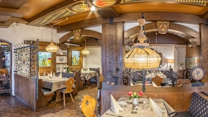 Un restaurant doté d’un sol carrelé à motifs hexagonaux, de meubles en bois et de lustres décoratifs.