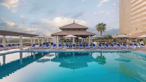 Uma piscina com espreguiçadeiras e um gazebo.