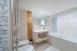 Un baño moderno con lavabo, espejo y bañera.