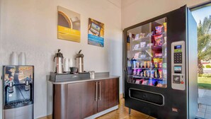 A hotel reception area with a coffee machine, a water dispenser, and a vending machine. - Motel 6 Santa Nella, CA - Los Banos (Gustine)