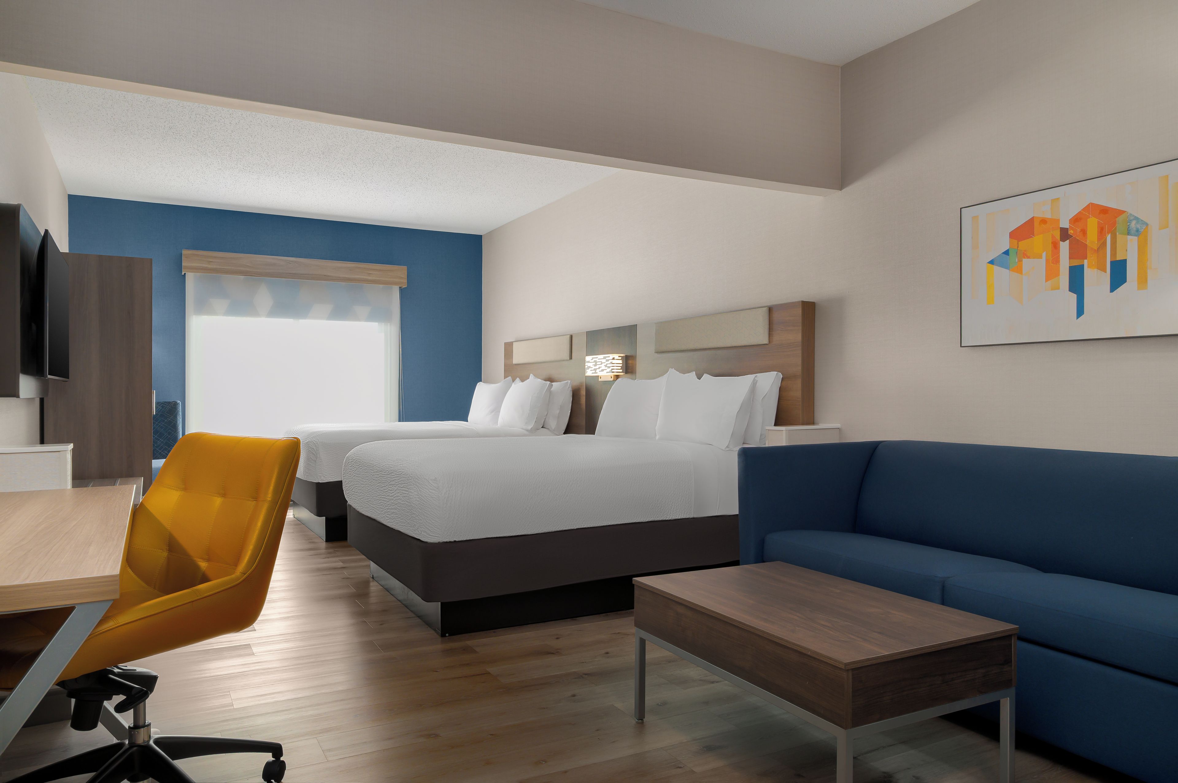 Una habitación de hotel con una cama, un sofá, un escritorio y una silla.