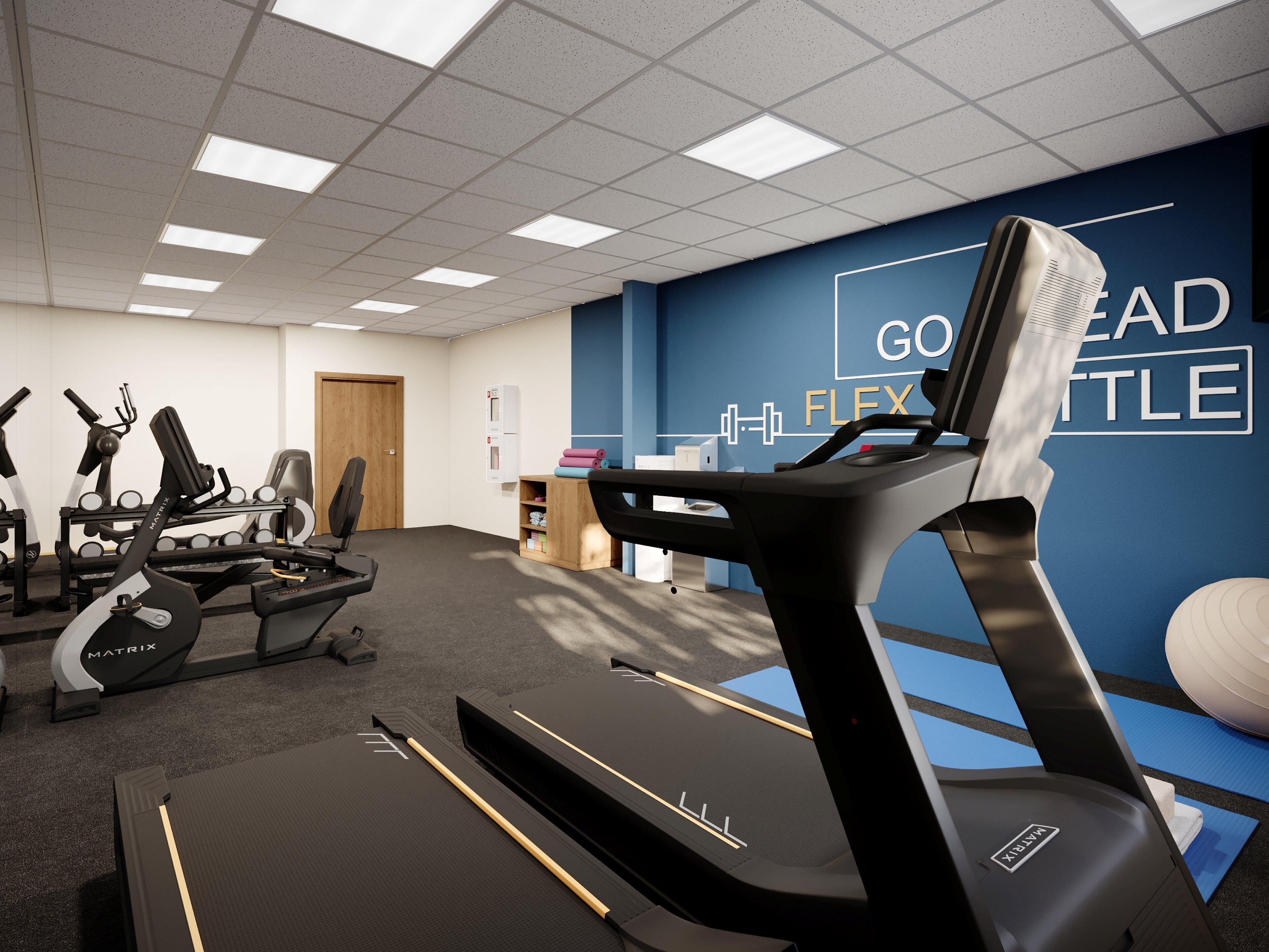 A gym with treadmills, exercise equipment, and a wall with motivational text.