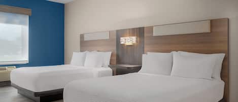 A hotel room with two beds, a large window, and a wall-mounted light fixture.
