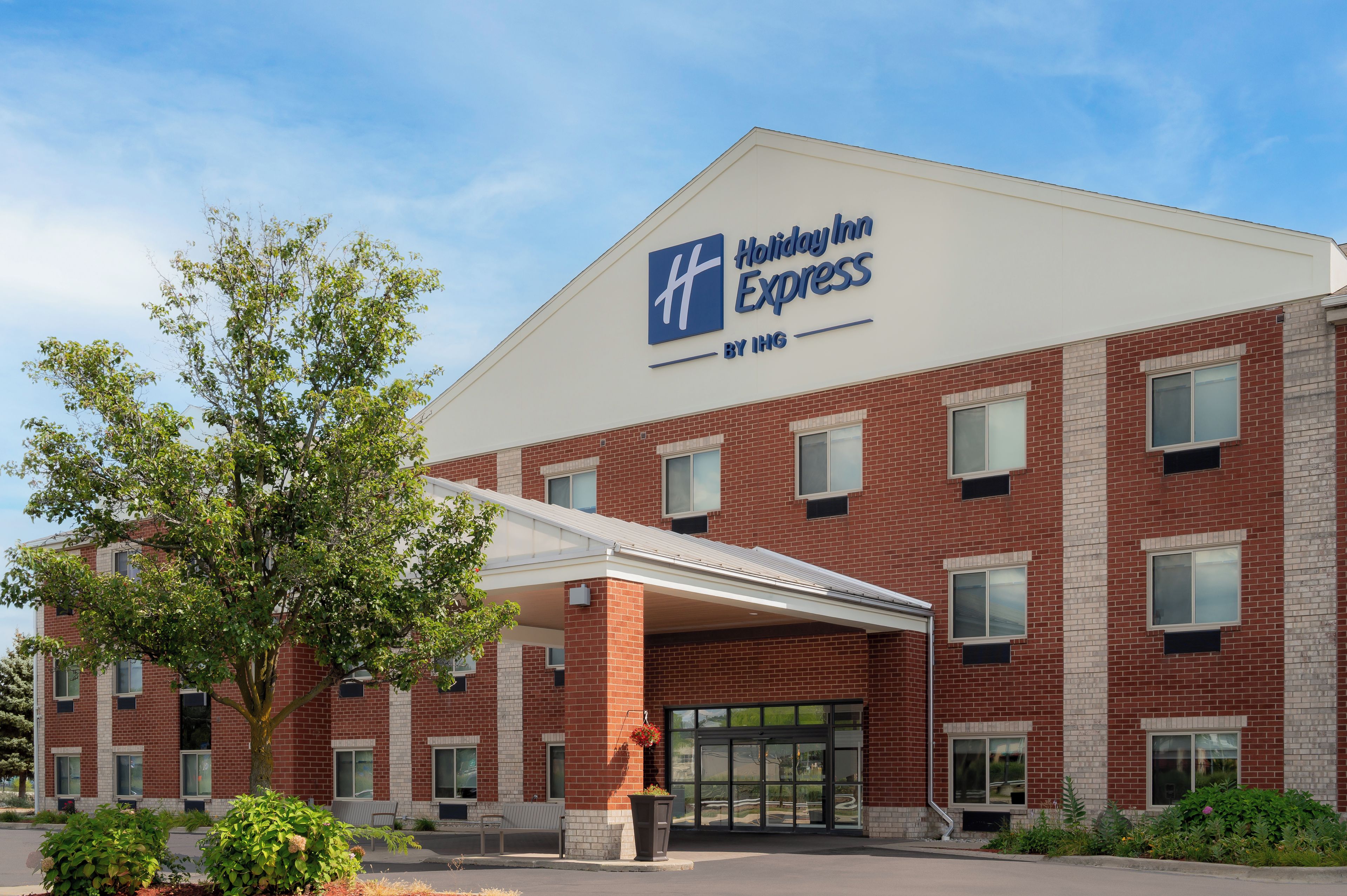 A Holiday Inn Express hotel with a brick facade, large windows, and a covered entrance.