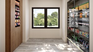 A hallway with a wooden shelf on the left, a large window with a view of trees, and a refrigerated beverage display on the right.