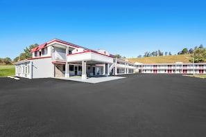 A large hotel with a white facade and red accents, featuring a covered outdoor area and multiple balconies. - Red Roof Inn Abingdon (Abingdon)