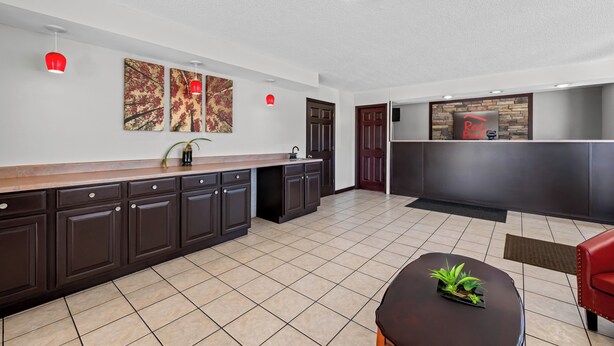 A modern kitchen with dark cabinetry, a wooden countertop, and a red pendant light. - Red Roof Inn Abingdon (Abingdon)