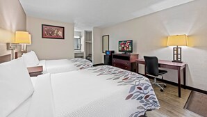 A hotel room with two beds, a desk, a TV, and a lamp. - Red Roof Inn Abingdon (Abingdon)