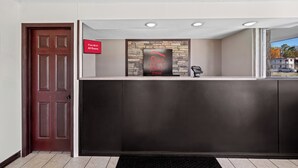 A reception area with a dark reception desk, a sign indicating free Wi-Fi, and a Red Roof Inn sign above the desk. - Red Roof Inn Abingdon (Abingdon)