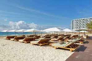 Sur la plage, chaise longue, parasol, serviettes de plage