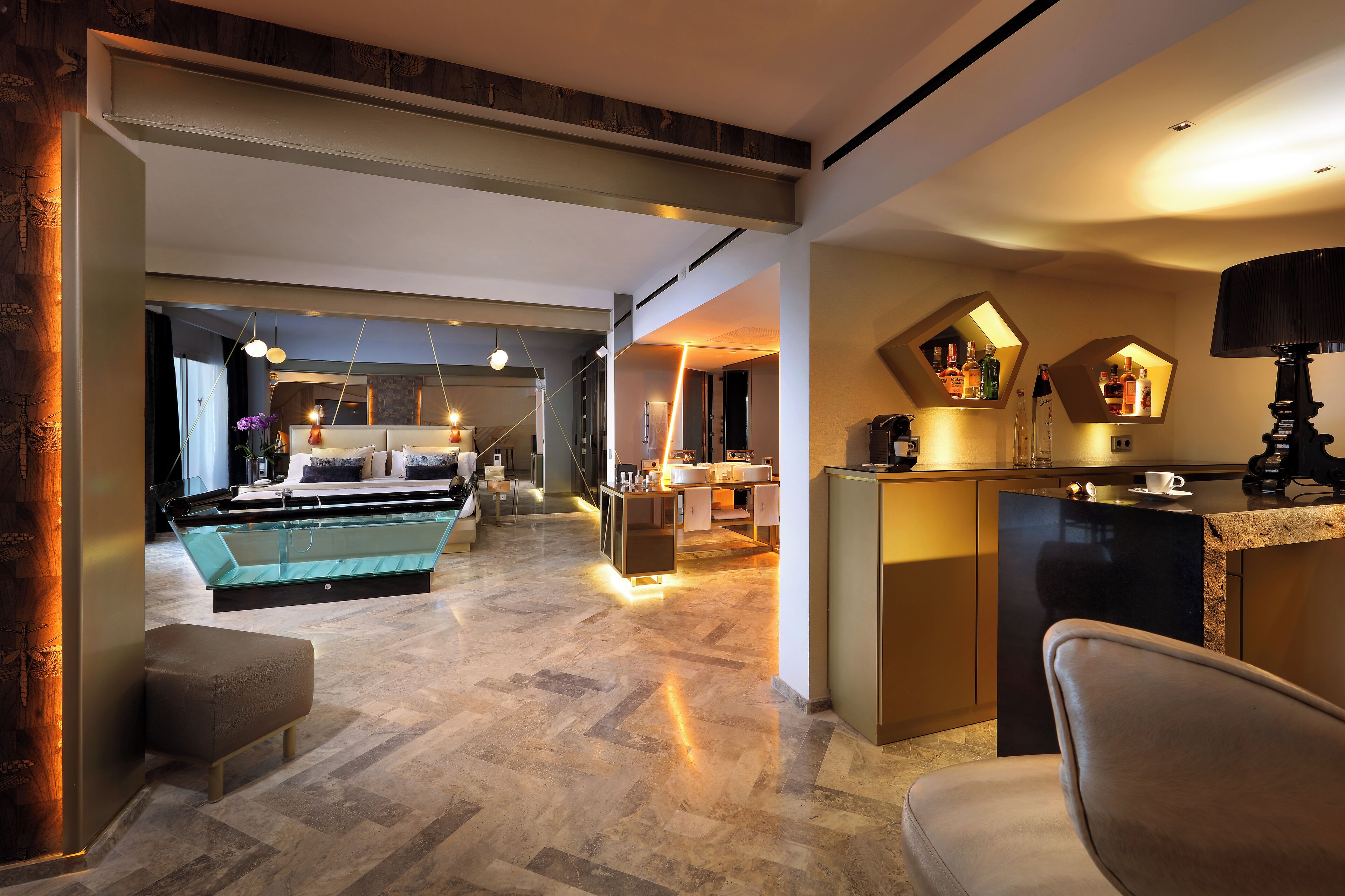 Una hall d'albergo moderna con un'ampia area salotto, una piscina e una cucina con illuminazione geometrica originale.