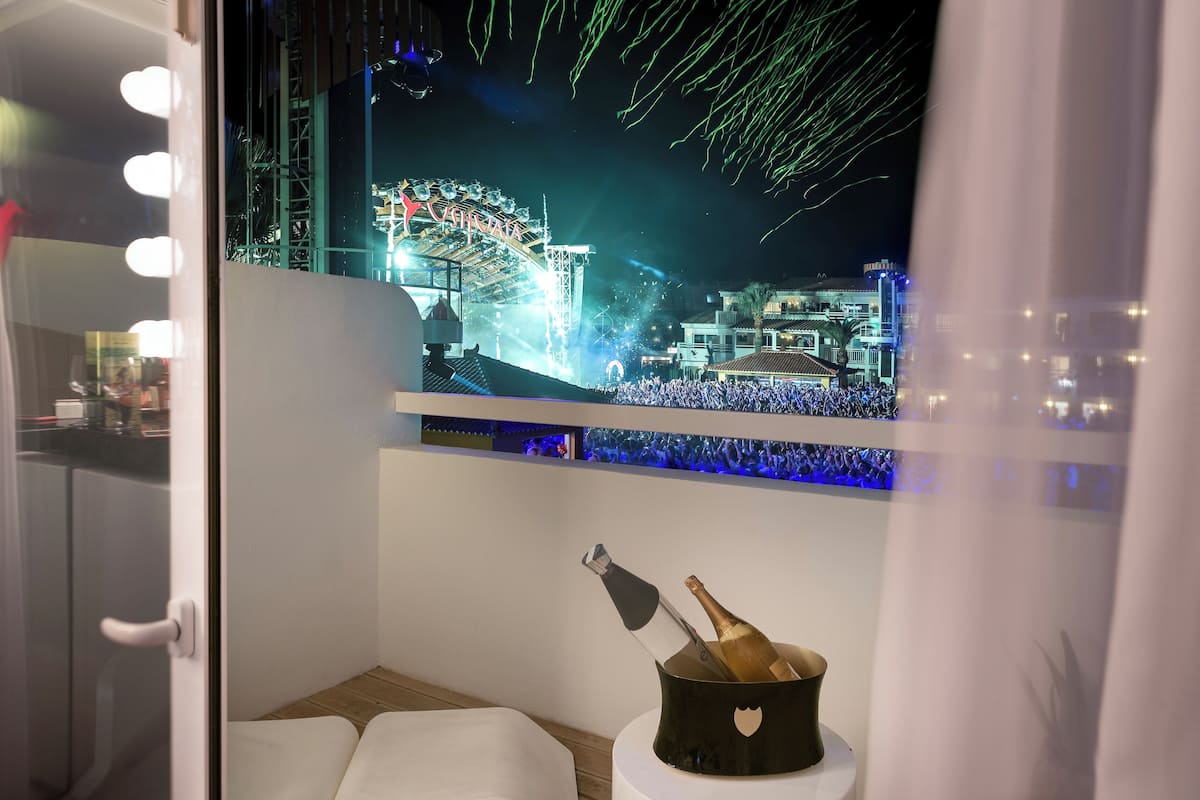 Ein Zimmer mit Blick auf ein Riesenrad und eine Menschenmenge bei Nacht.