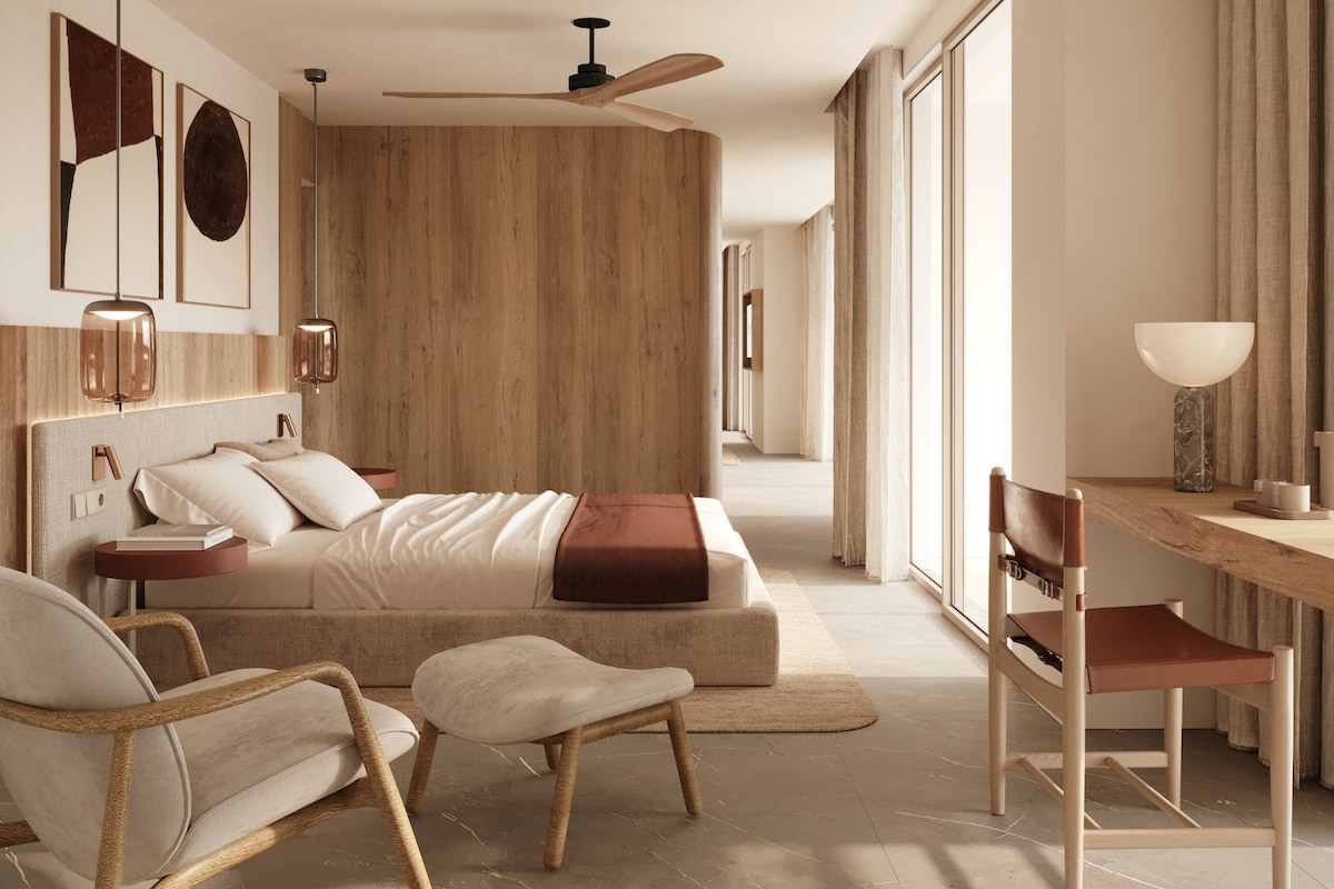 A modern bedroom with a bed, bedside tables, a desk, chairs, and a ceiling fan.