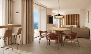 A modern living room with a round table, chairs, a sofa, and a view of the sea.