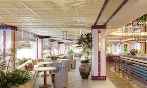 A modern interior with a bar area, seating, and potted plants.