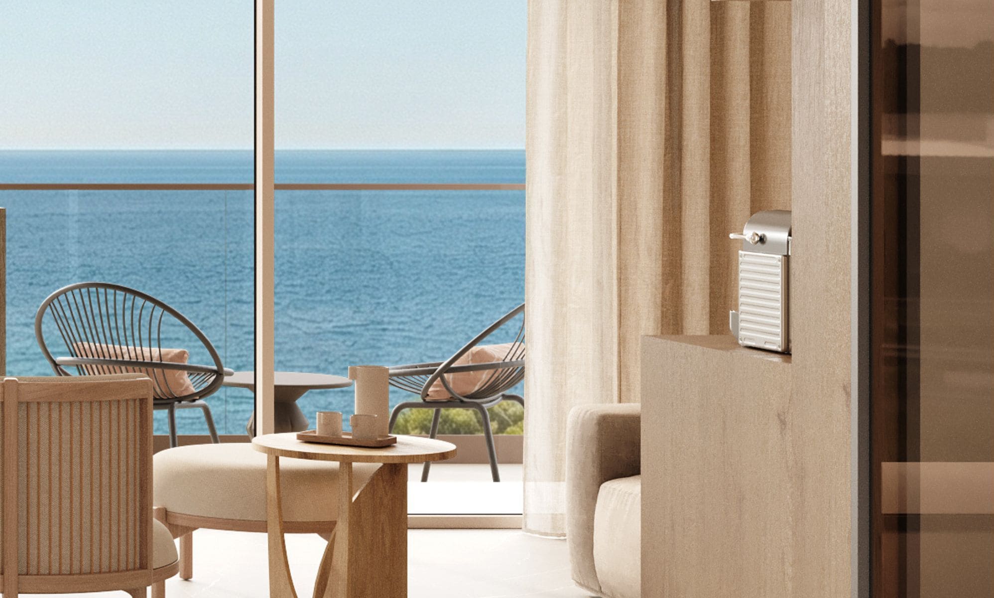 Een balkon met uitzicht op zee, voorzien van stoelen en een tafel.