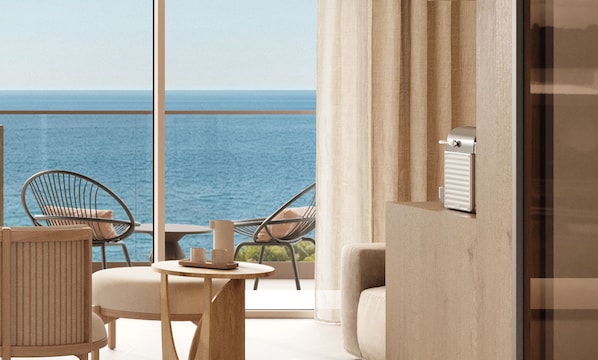 Un balcón con vistas al mar, amueblado con sillas y una mesa.